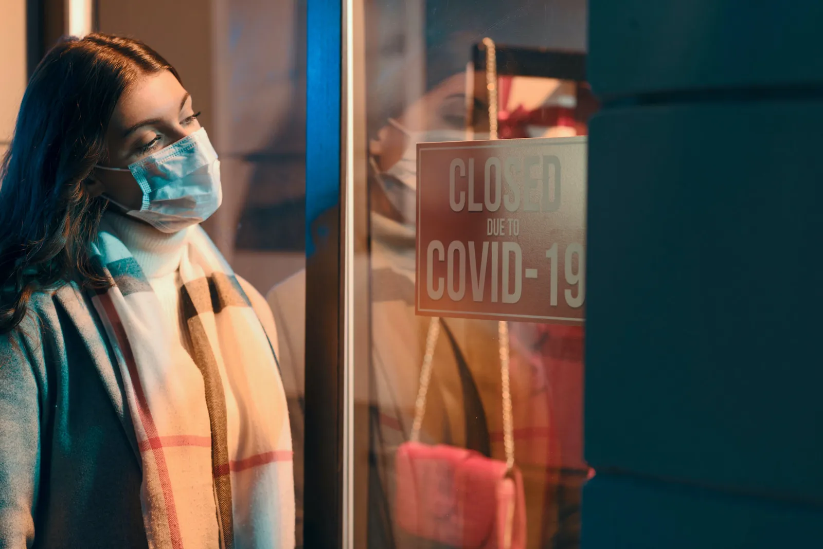An image of a woman wearing a mask in front of the store